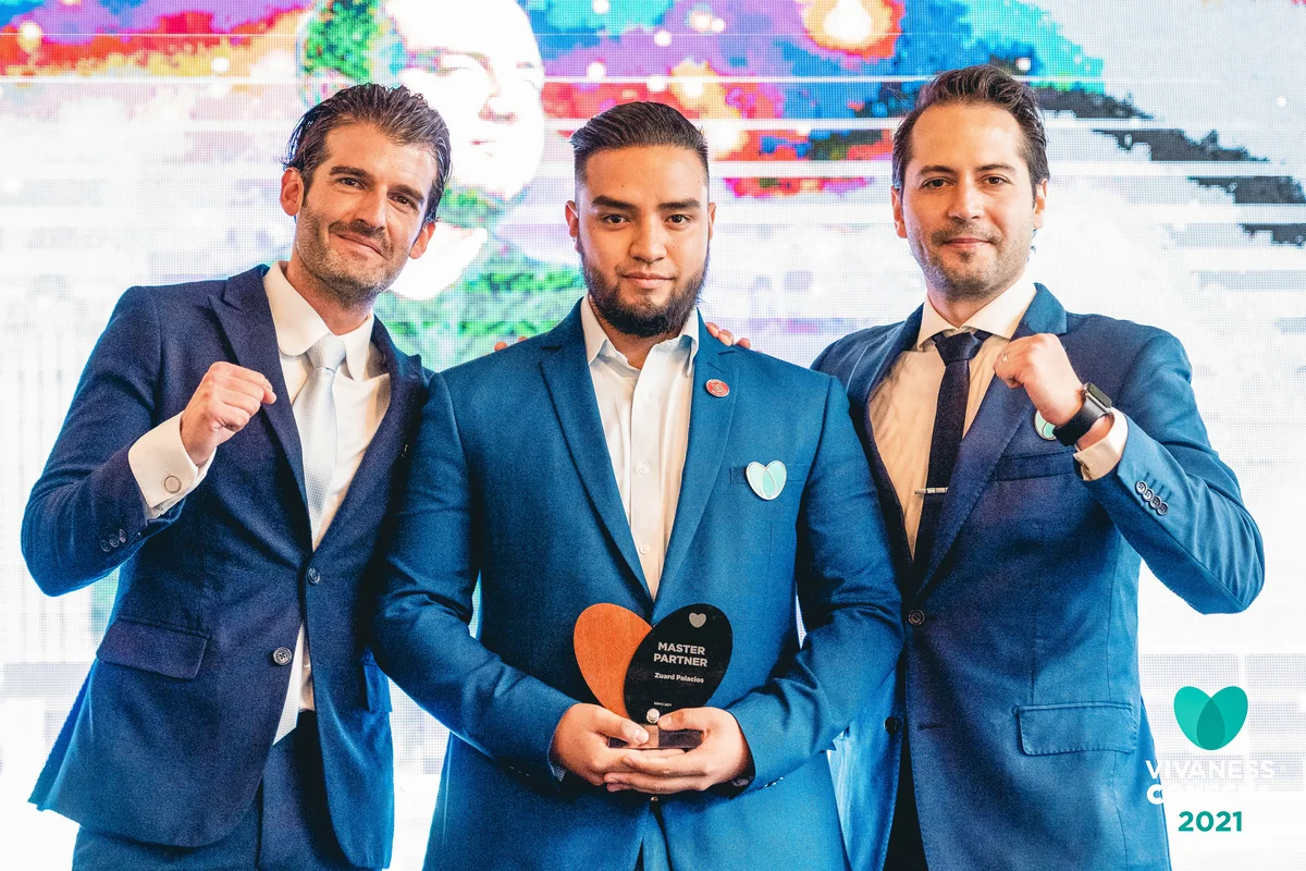 Zuard Palacios recibiendo el reconocimiento Master Partner de Vivaness en 2021, junto a dos directivos de la organización